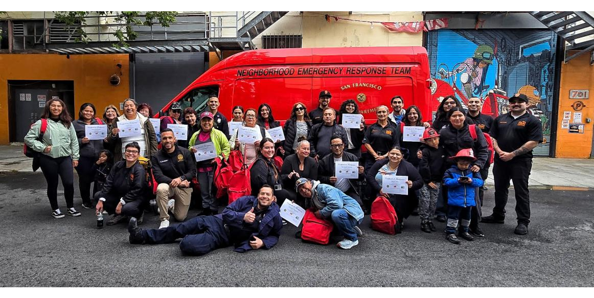 A group of people holding certificates standing in front of a red van that says Neighborhood Emergency Response Team