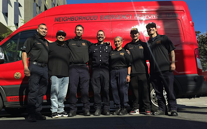 A group of firefighters standing in front of a red van that reads Neighborhood Emergency Response Team