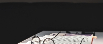 Opened book with glasses in between the pages
